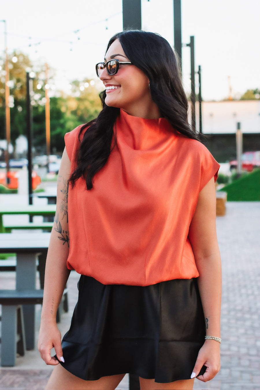 Woman wearing rust colored cap sleeve blouse 