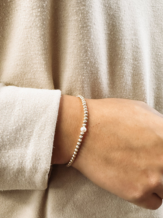 stretchy beaded bracelet with corrugated beads and a freshwater pearl.