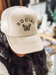 cream colored hat with "social butterfly" embroidered