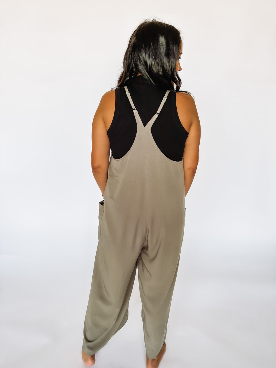 back of olive jumpsuit and black tank top