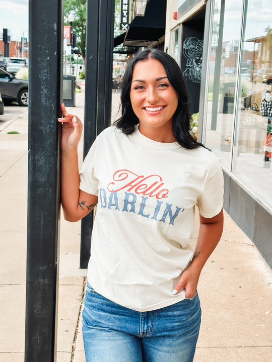 Graphic tee with vintage typography featuring "Hello Darlin'" in a blue and red color way.