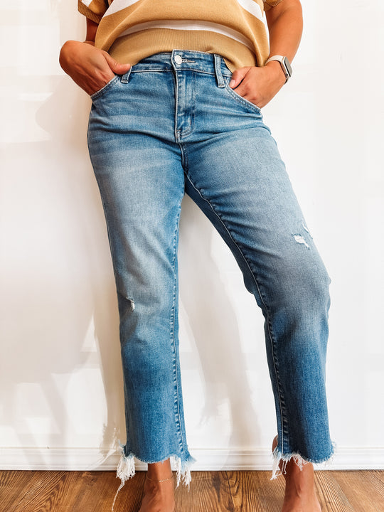 Medium wash ankle jeans with raw hem and some distressing.