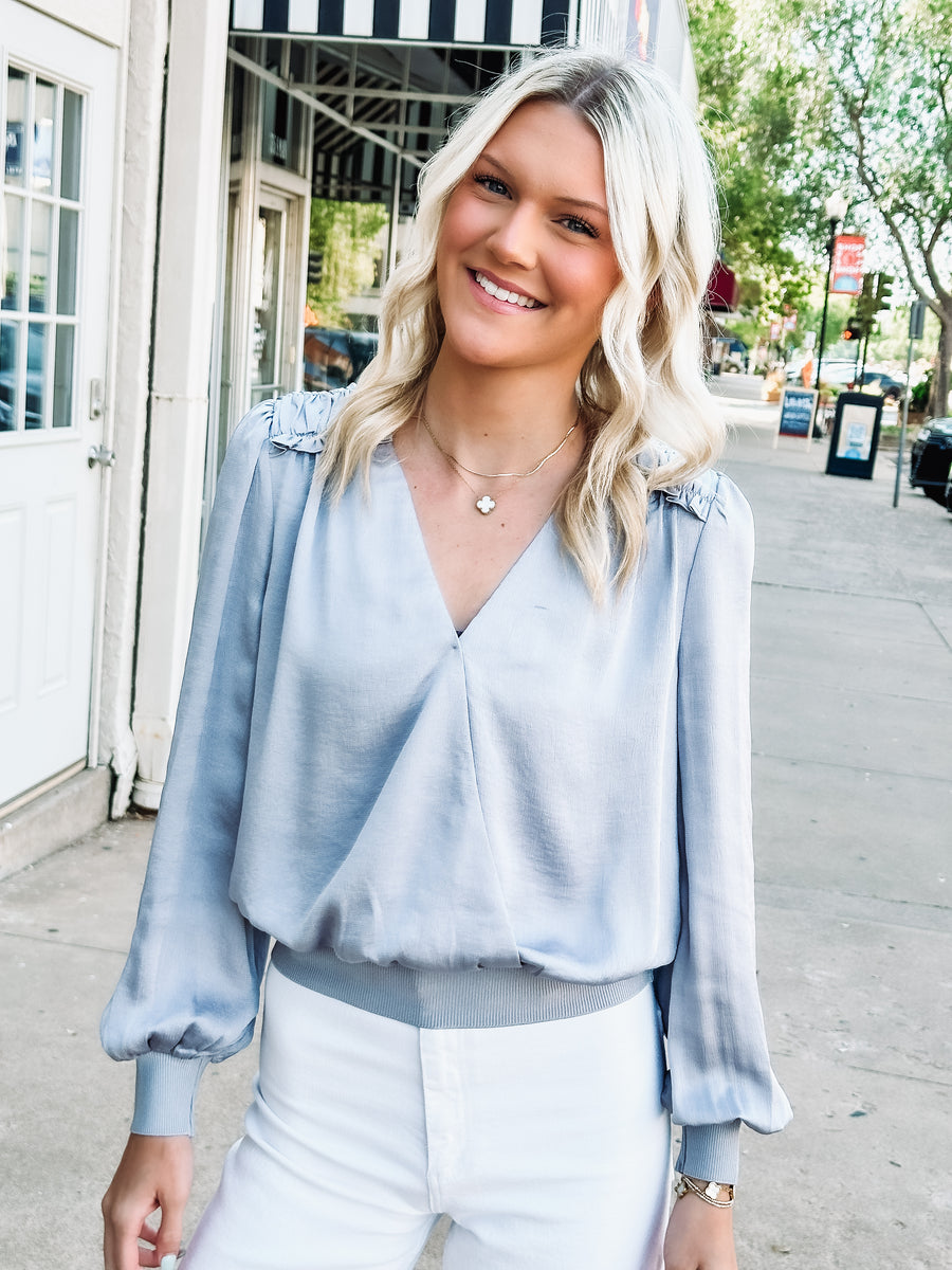 silver colored satin blouse with ruffle detail