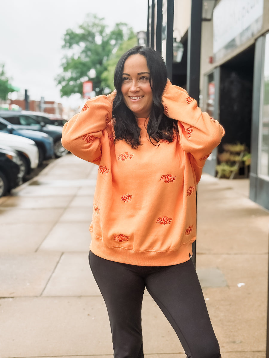 Sherbert orange Oklahoma State long sleeve crew neck with embroidered OSU logo in a slightly darker orange.