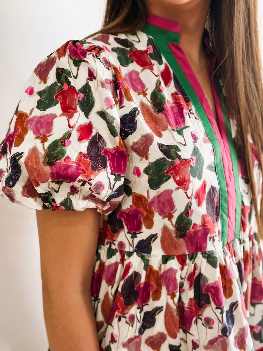 Green, Wine, Purple, Pink and Orange floral mini dress with puff sleeves and pink and green contrast seaming.