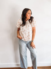 White button up blouse with pink floral detailing.